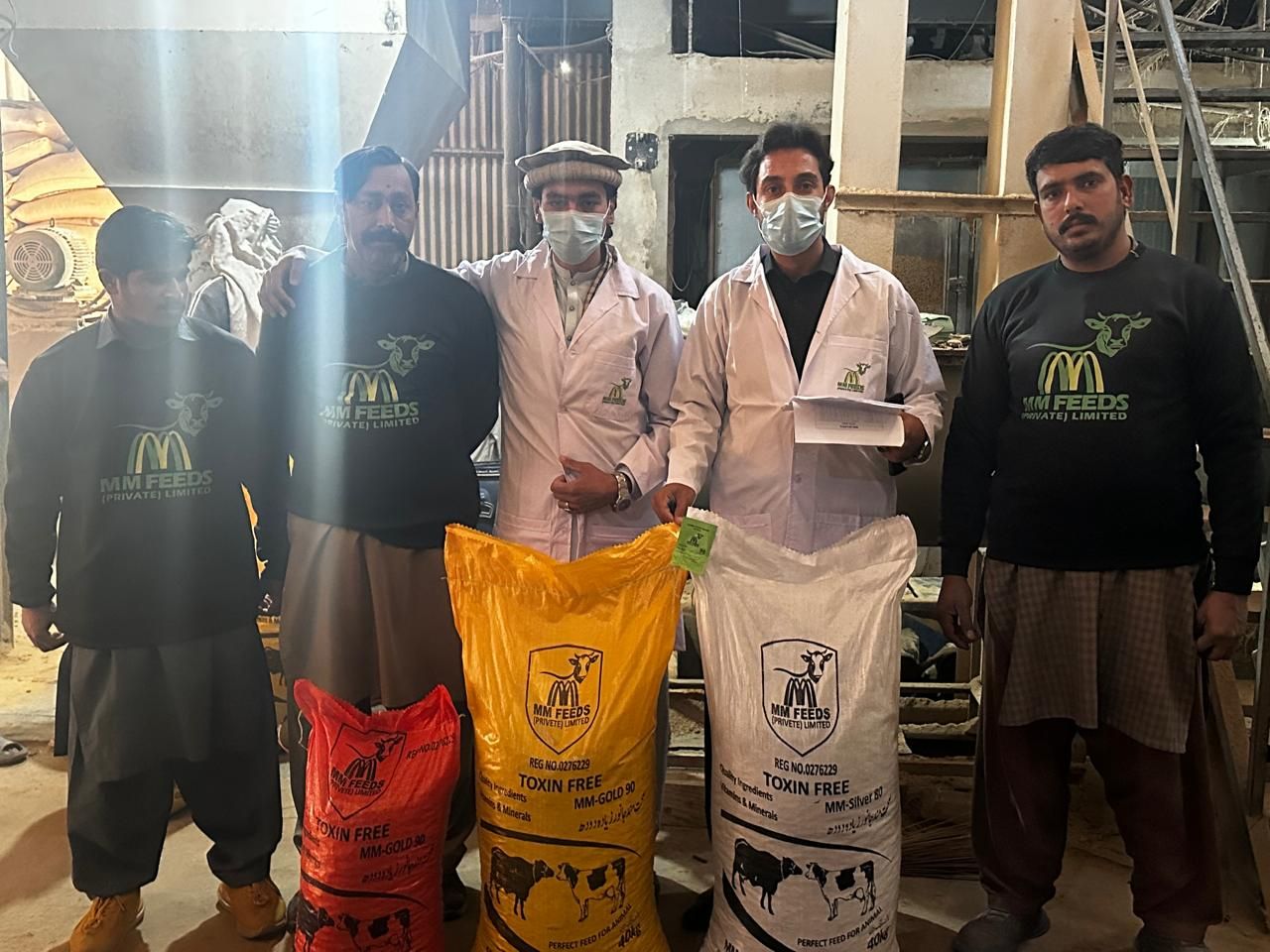 MM Feeds staff and quality officers at the mill with Gold 90 and Silver 80 bags